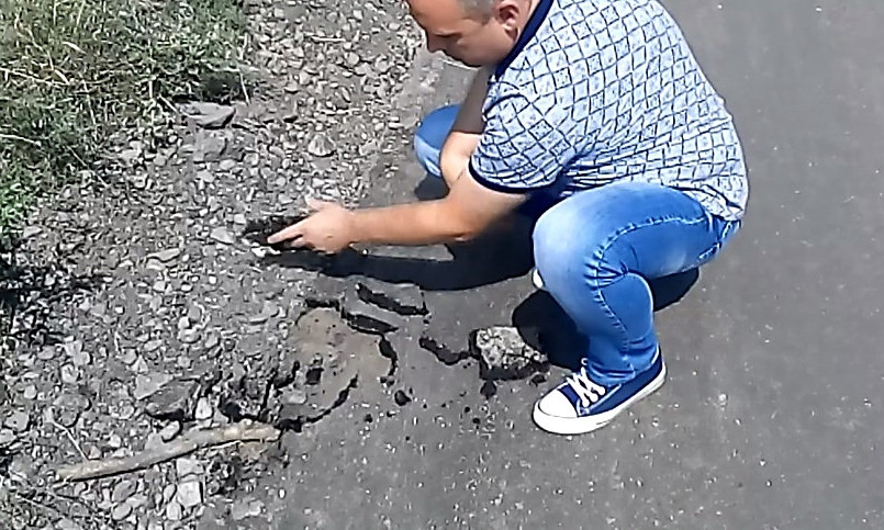 «Привет главе администрации»: николаевский депутат рукой снял асфальт, уложенный поверх земли