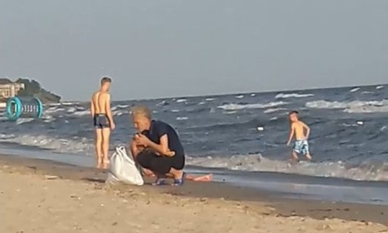 В Коблево на пляже продавщица уронили пирожок, а после слизала с него песок