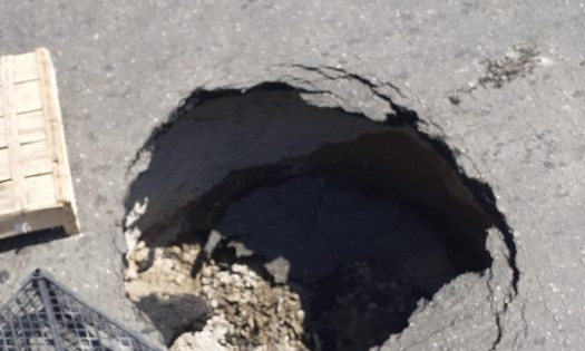 На Богоявленском проспекте посреди проезжей части образовалась глубокая яма, в которой застрял автомобиль